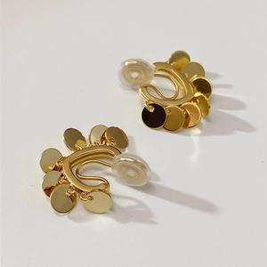 Macro shot of gold-plated non-pierced ear clips with cascading small metal discs