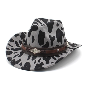 Detail of cow print cowboy hat with brown leather band and vintage silver metallic studs
