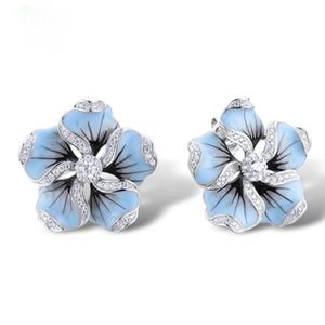 Detailed view of blue enamel daisy stud earrings with sparkling white cubic zirconia crystals