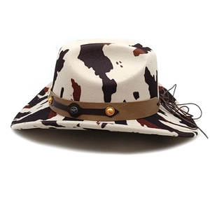 Detail of cow print cowboy hat with brown leather band and silver star emblem