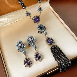 Détail macro du coffret collier vintage serpent avec gemmes violettes et perles noires en boîte