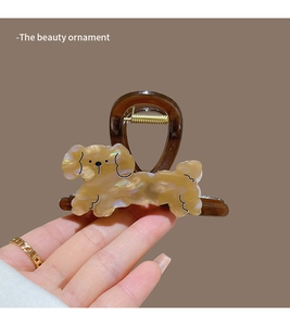 Detail of cute beige puppy shark hair clip with brown resin and metal spring