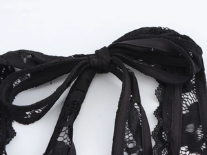 Dettaglio del fiocco in pizzo nero con motivi floreali intricati e trama a rete fine