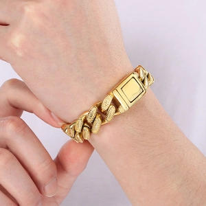 Detail of gold Cuban link bracelet showing the textured metal links and secure square clasp