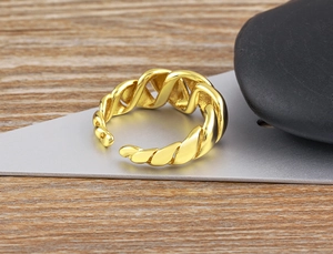 Macro view of adjustable 18K gold plated twisted texture ring on natural stone