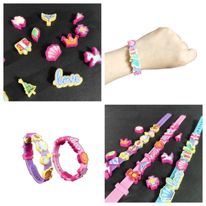 Close-up of DIY charm bracelet set featuring unicorn and crown silicone wristbands
