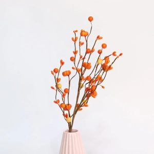 Close-up of artificial pumpkin and berry branches in a vase for autumn home decor
