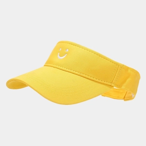 Detail of yellow cotton sun visor featuring white smiley face embroidery and stitching