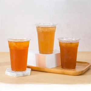 Detailed view of three thick PET plastic cups with flat lids filled with iced milk tea