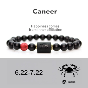 Detail of Cancer zodiac bracelet with matte black beads and red marble stone accent