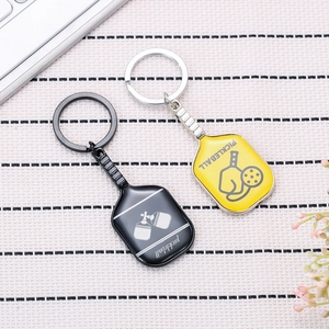 Miniature pickleball paddle metal keychains in black and yellow with silver frames