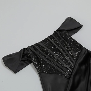 Détail de broderie de paillettes noires et encolure Bardot sur la robe de soirée