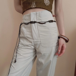 Detail of handcrafted dark brown wooden bead belt paired with vintage patterned crop top
