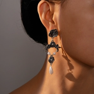 Close-up of vintage floral drop earrings with black roses and elegant teardrop pearls