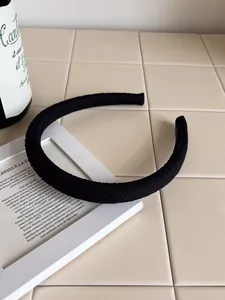 Close-up of black wide headband with textured fabric on elegant French style background