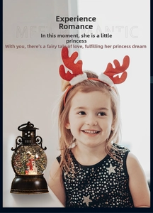 Christmas musical snow globe lantern with snowman and tree, held by a smiling girl