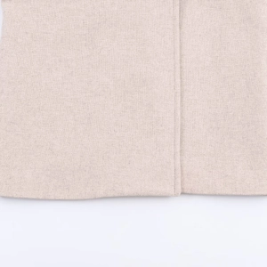 Dettaglio cappotto invernale beige con texture del tessuto e cuciture doppie di qualità
