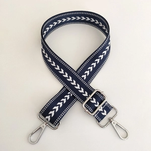 Macro shot of dark blue arrow pattern nylon strap with adjustable silver metal buckles
