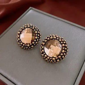 Vintage gold-tone round stud earrings with faceted brown crystal and beaded edges