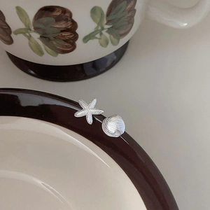Minimalist 925 sterling silver starfish and shell stud earrings on vintage ceramic pot