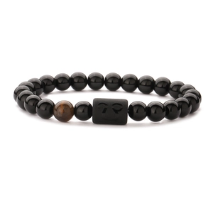 Detailed macro view of Gemini zodiac obsidian bracelet with brown tiger eye bead