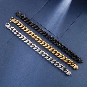 Detailed view of silver, gold and black Cuban bracelets with lion head clasp on blue