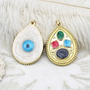 Detailed view of double-sided gold 18K teardrop evil eye charm with colorful crystals