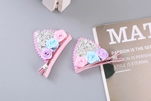 Détail de pinces à cheveux oreilles de chat roses avec paillettes et roses en tissu