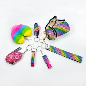 Rainbow rhinestone self-defense keychain set with alarm and heart pom pom on white background
