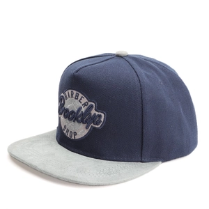 Détail du tissu sergé marine et visière en daim gris avec broderie Barber Brooklyn