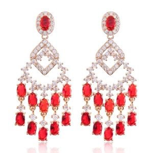 Detailed macro view of vintage gold chandelier earrings with red gems and white zircons