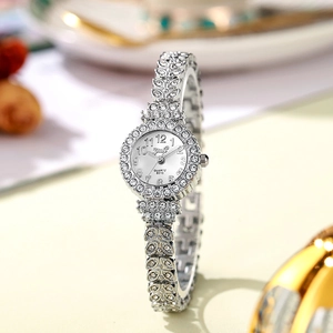 Macro view of the silver leaf-shaped strap and diamond bezel of this quartz watch