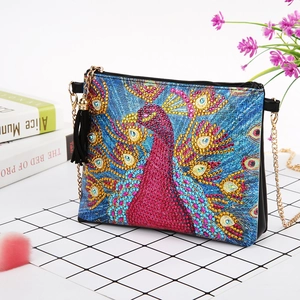 Detail of DIY diamond painting handbag with colorful peacock pattern and gold chain