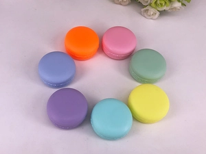 Top view of seven colorful macaron-shaped cosmetic jars arranged in a circle