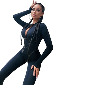 Detail of slim fit black jumpsuit featuring front zipper and shiny side webbing details