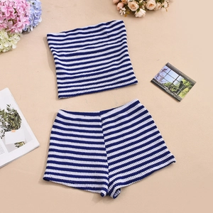 Flat lay of blue and white striped knit tube top and shorts set on warm beige background