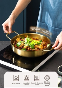 Golden stainless steel seafood pot with double handles heating on an induction cooker