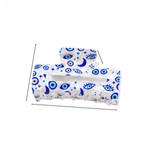 Detailed dimensions of white claw clip with blue evil eye print and gold accents