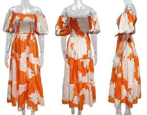Détail d'une robe longue à fleurs, épaules dénudées avec des manches bouffantes