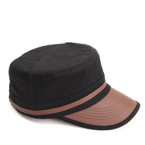 Detail of vintage cadet cap with black canvas, brown leather brim and reinforced stitching