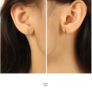 Détail des boucles d'oreilles en forme de U en métal doré et argenté sur modèle