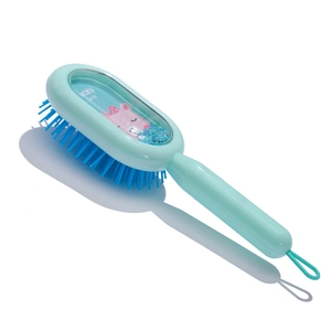 Detail of green hair brush featuring blue bristles and glitter liquid sand bear art