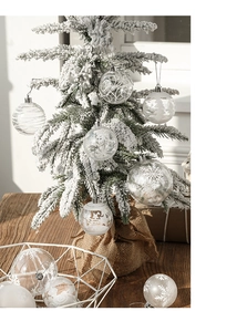 Detailed view of clear and frosted white Christmas balls with snowflake patterns in a box