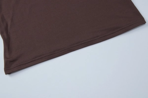 Detailed close-up of double-stitched hem on dark brown elastic dress fabric
