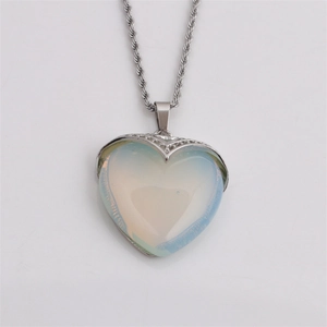 Detailed close-up of a silver heart-shaped opal pendant on a classic twisted chain