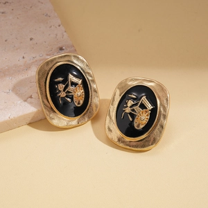 Boucles d'oreilles vintage en or avec émail noir et relief de calèche dorée élégant