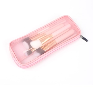 Dettaglio della borsa trucco in rete rosa con pennelli, in nylon traspirante con tocchi dorati