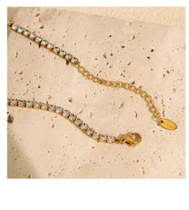 Détail macro du collier tennis doré avec zircons cubiques et fermoir mousqueton