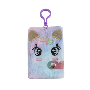 Dettaglio macro del mini taccuino unicorno di peluche con ricamo arcobaleno e morbido