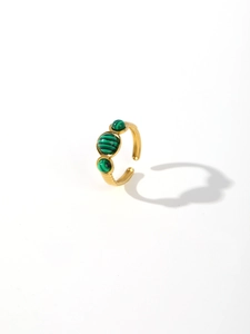 Detailed close-up of wide gold-plated steel ring with three oval green malachite stones